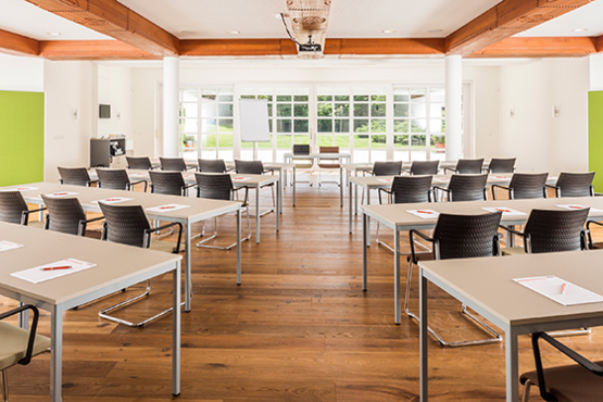 Besprechungsraum mit mehreren Reihen von Tischen und Sesseln